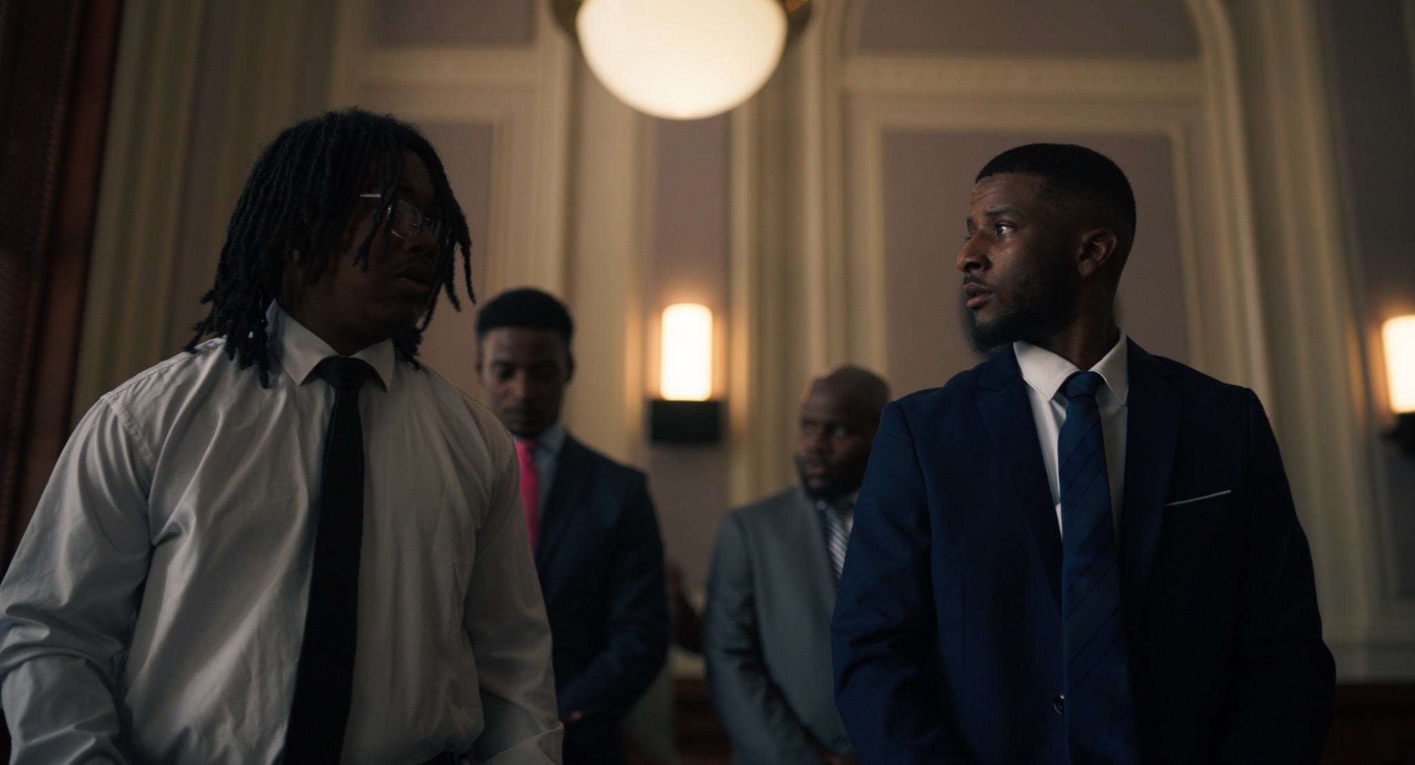 Film still from Joseph showing men in formal attire